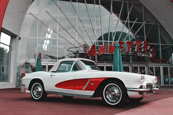 A classic blue vintage car parked in front of a retro diner.