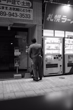 Technician performing maintenance on a vending machine in an industrial park.