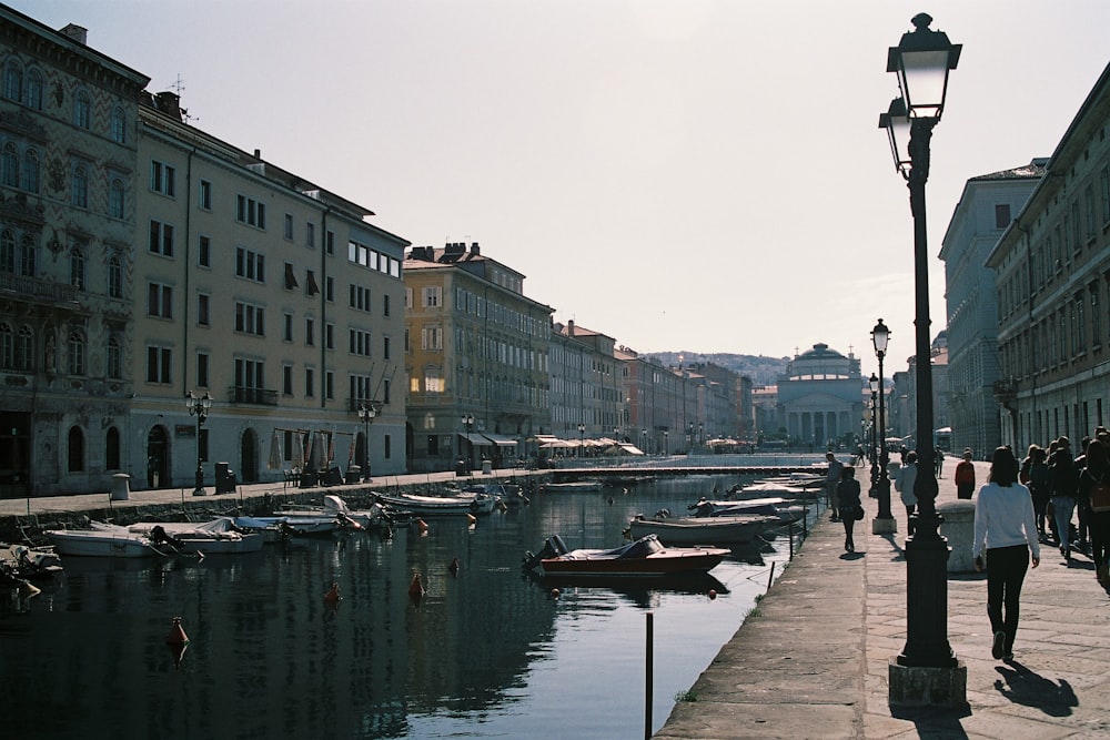 Persone in piedi accanto a specchio d'acqua e edifici durante il giorno