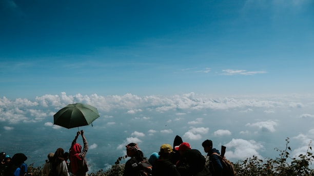 Anime-style guild members standing together atop a cloud, looking toward a bright blue sky.