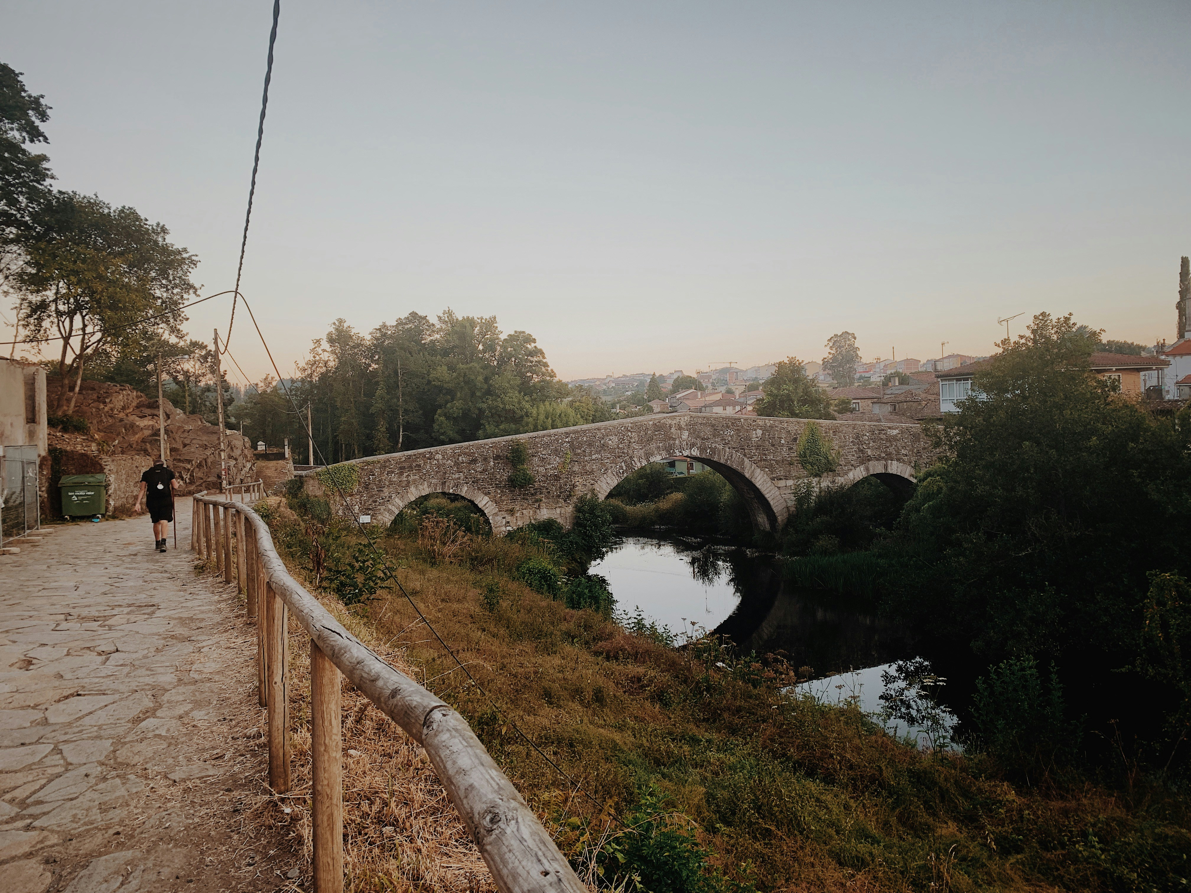 Persona che cammina sulla strada lungo il fiume durante il giorno