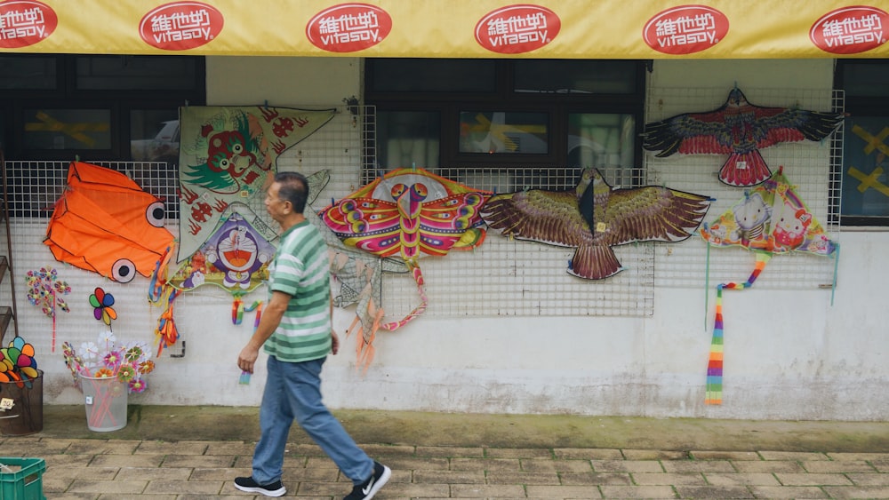 hombre caminando al lado de la tienda durante el día