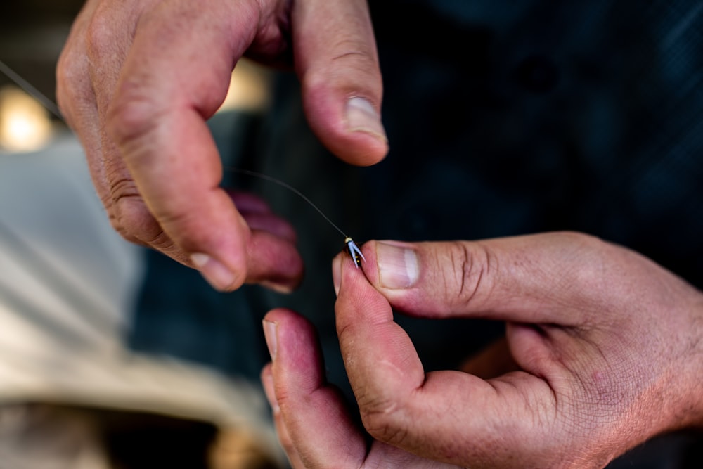 person holding fishhook with line