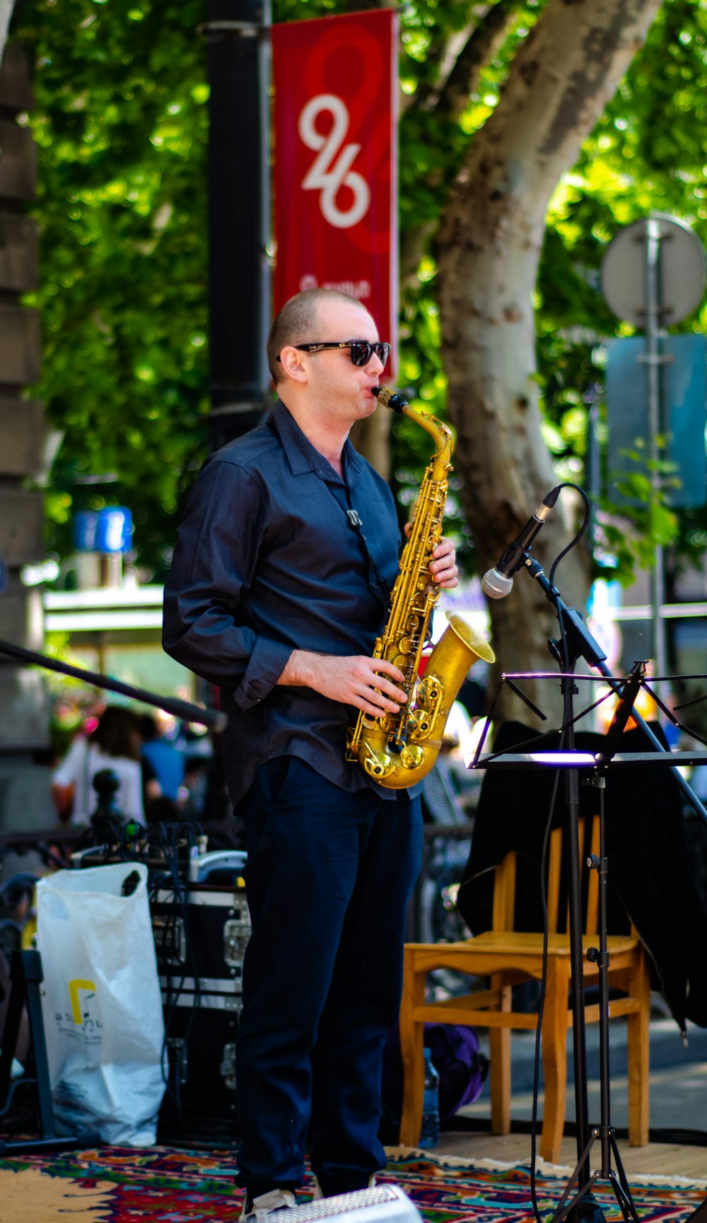 man playing saxophone near stage during daytime
