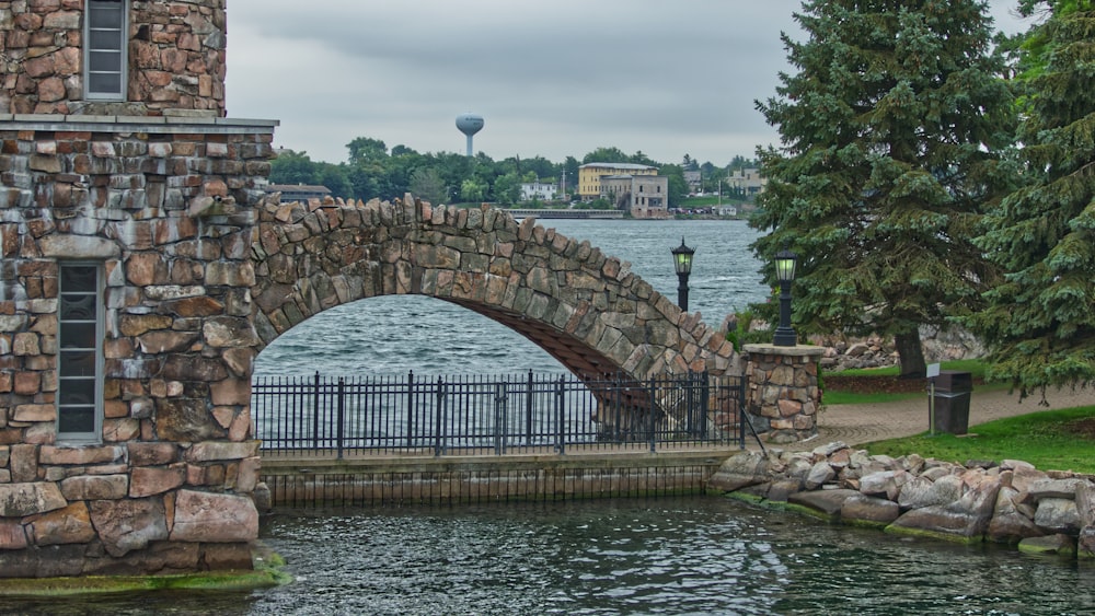 wrought iron fence under arch stone bridge