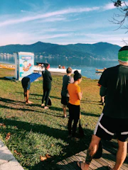 people standing on grass near body of water