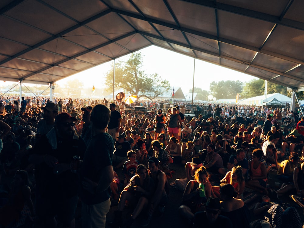 a large group of people sitting under a tent