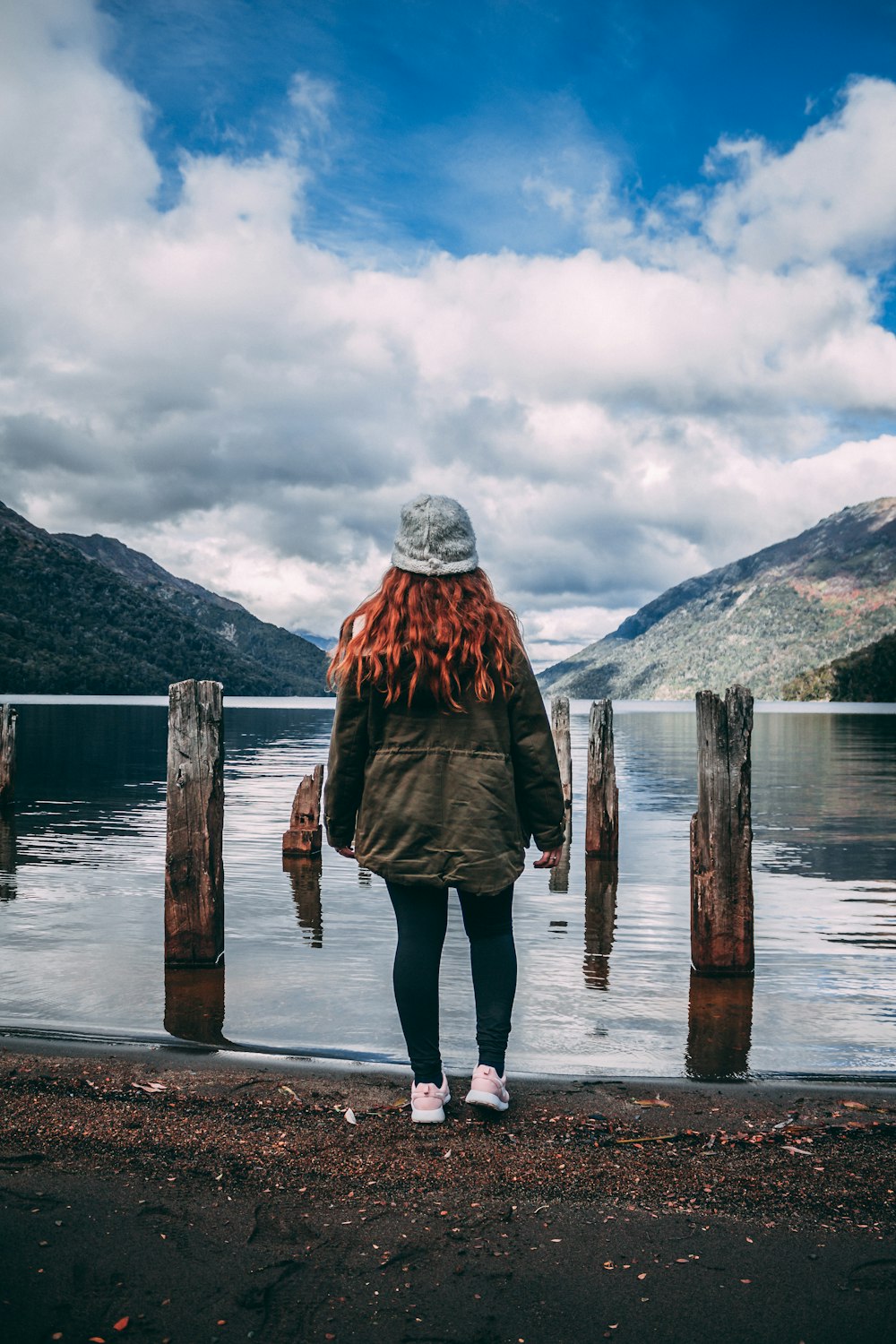 woman standing facing body of water