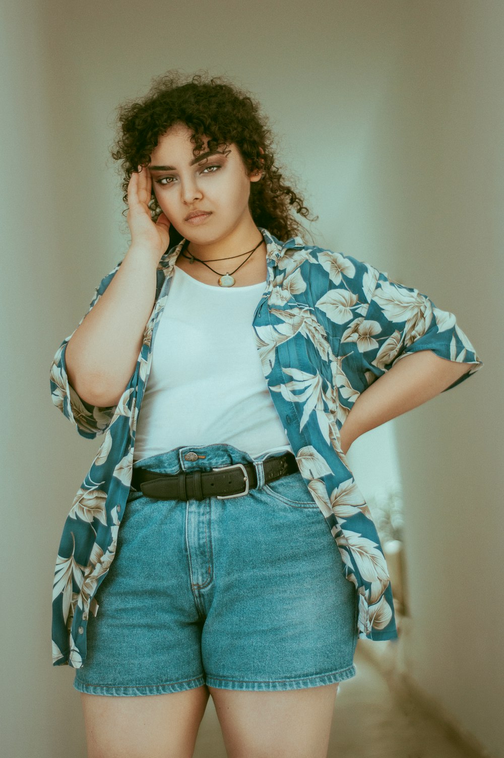 woman wearing blue and white floral shirt and blue denim shorts