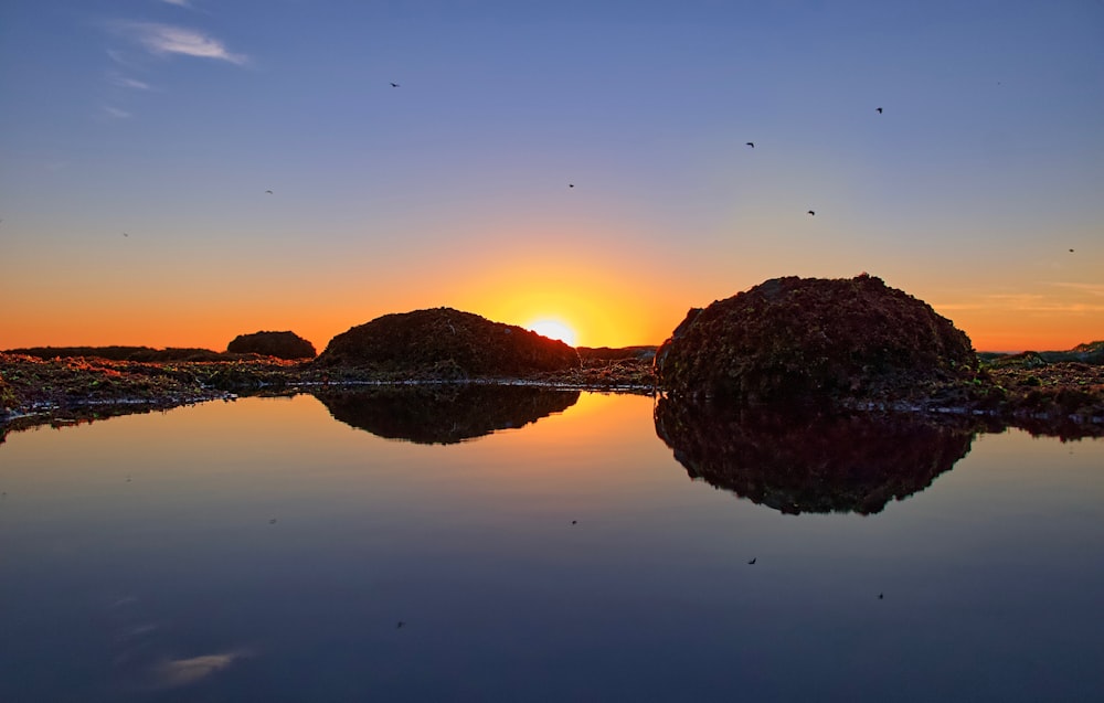 orange setting sun over sea with islets