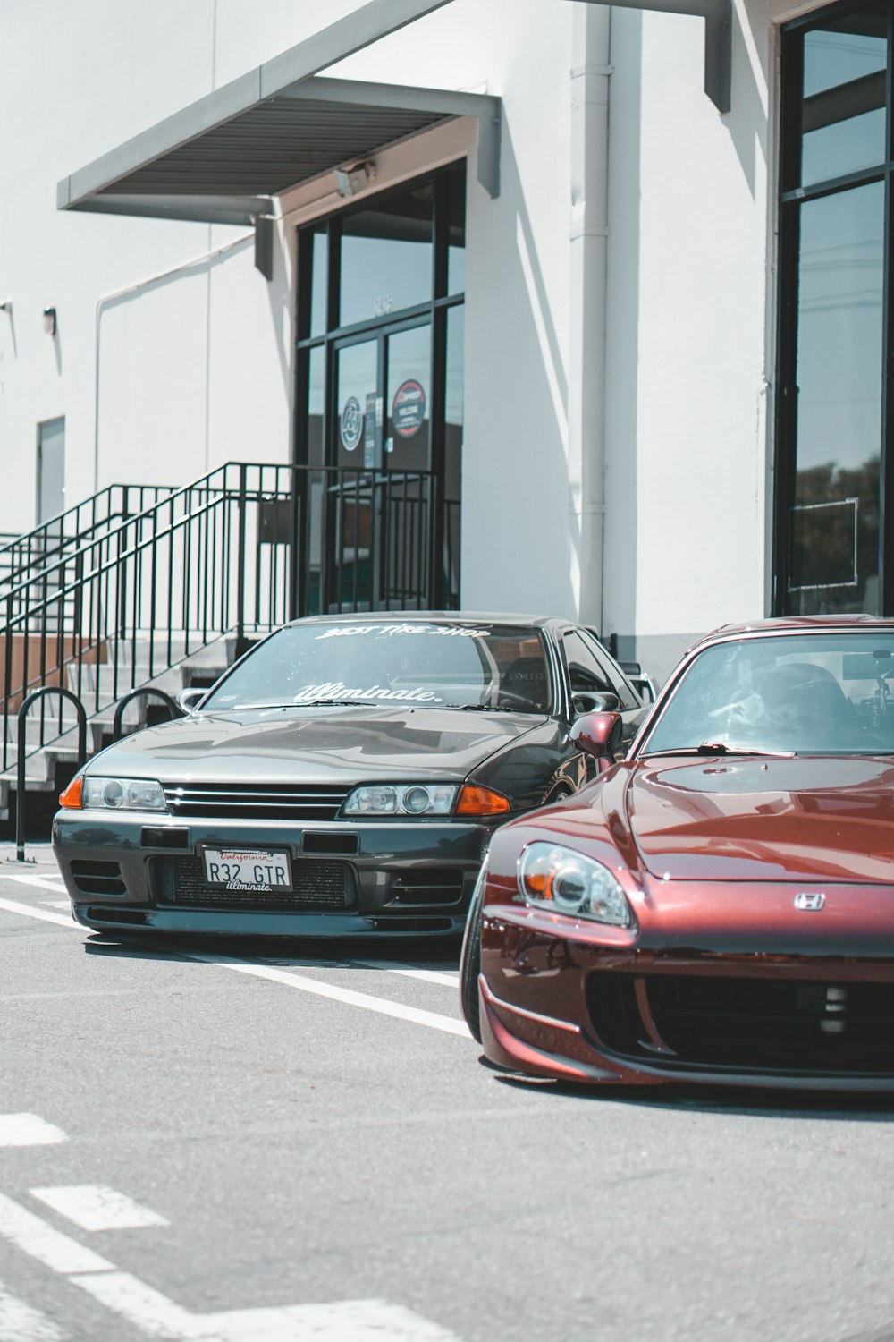 two sport cars parked in front of building