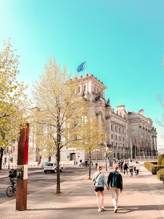 people walking near trees and building in Reichstag Building Germany