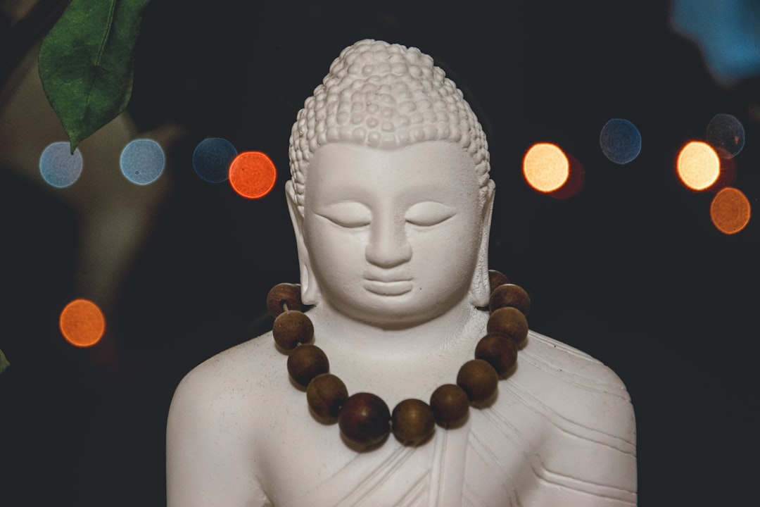 white buddha figurine with brown wooden beads necklace
