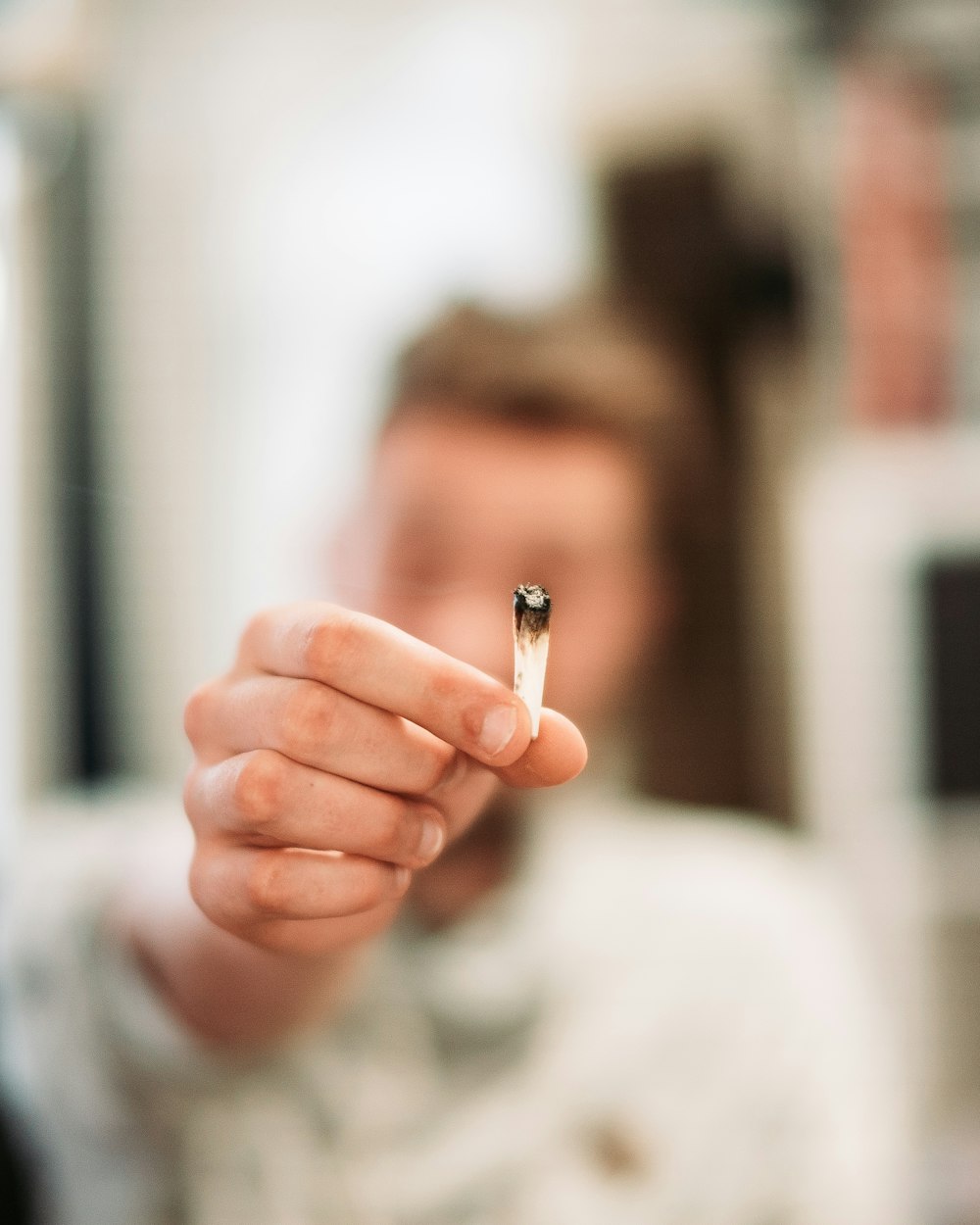 mujer sosteniendo la colilla de cigarrillo