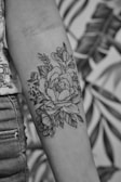 grayscale photo of floral arm tattoo