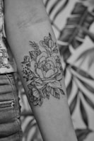 grayscale photo of floral arm tattoo