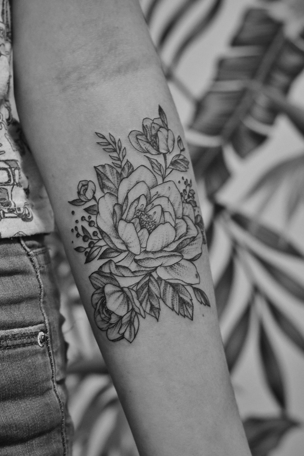 grayscale photo of floral arm tattoo