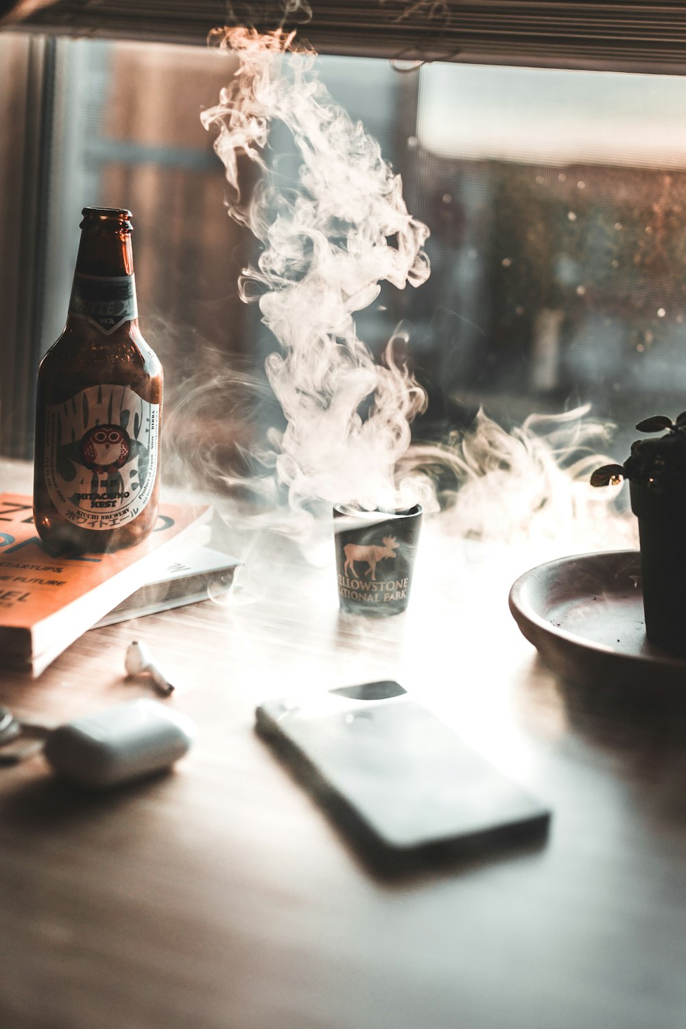 closeup photo of smartphone on table beside labeled glass bottle