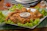 Close-up of golden crispy breaded chicken tenders on a rustic plate.