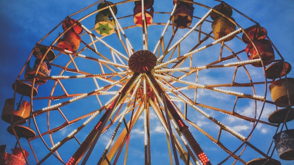 A colorful Ferris wheel illuminated against a twilight sky.