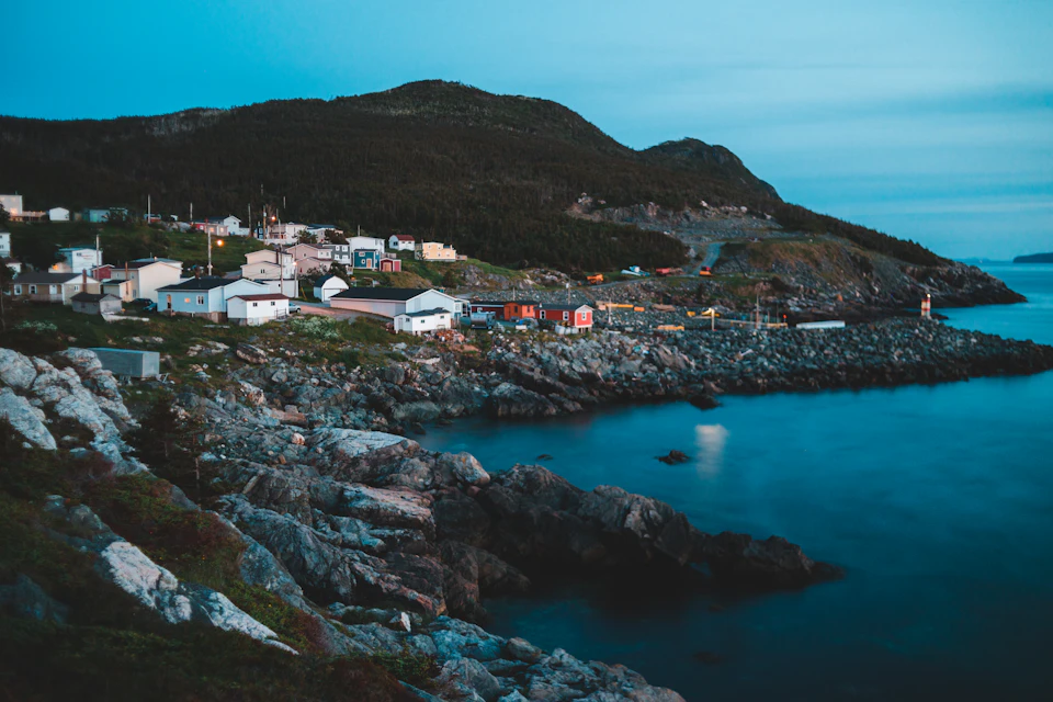 Serene coastal town perched on a rocky cliff overlooking the vast ocean below