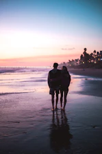 A couple enjoying a sunset walk on a pristine northern Madagascar beach.