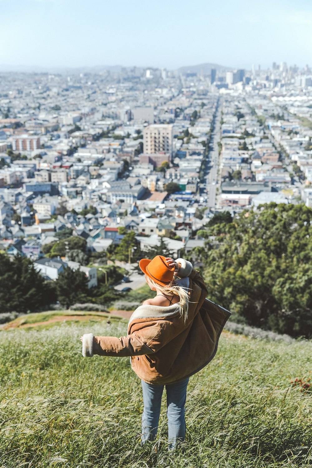 child wearing brown jacket on hill during daytime