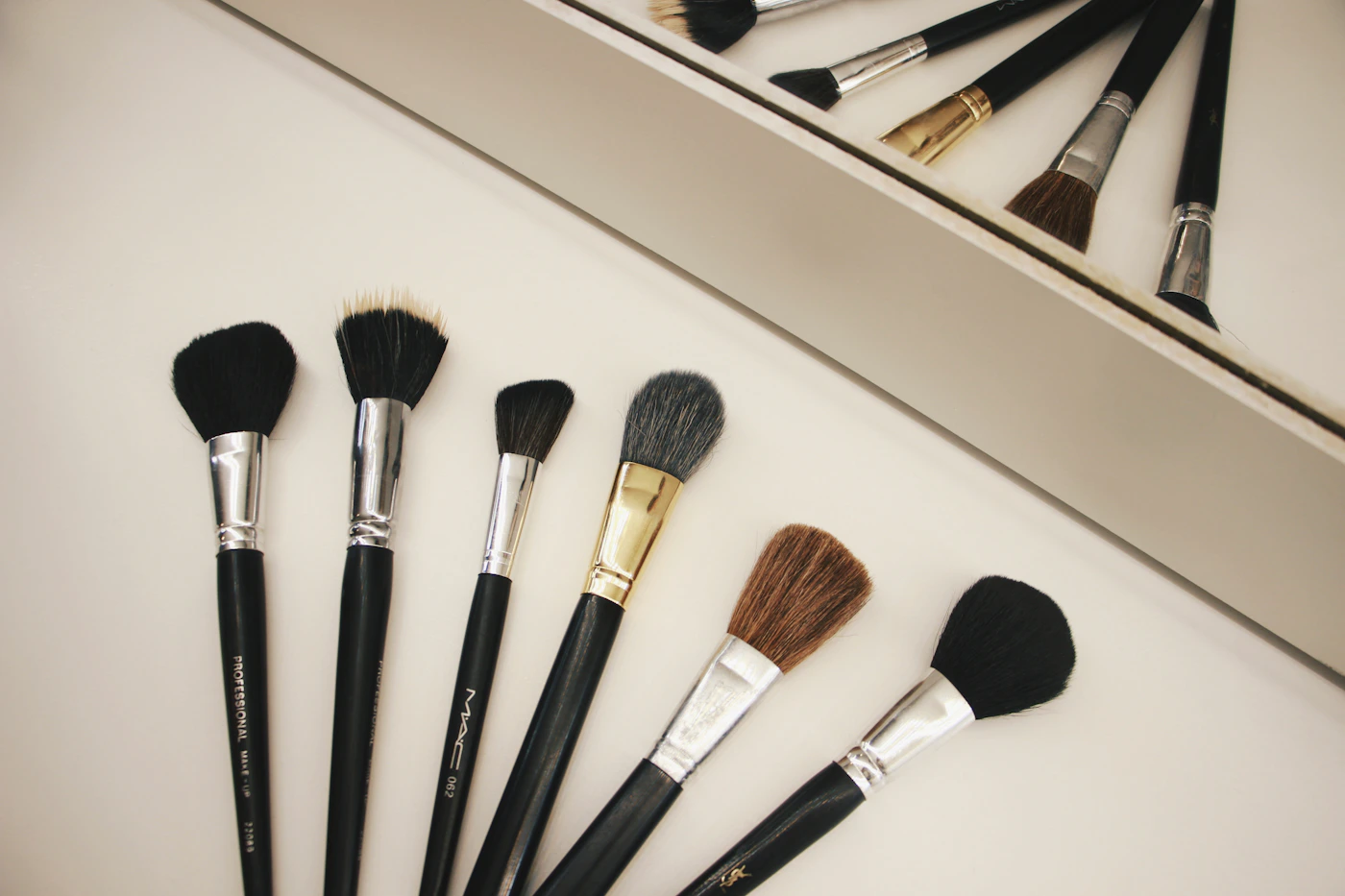 Beauty brushes and tools arranged on a neutral surface