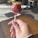 Close-up of a hand holding an elegantly decorated gourmet cake pop with delicate swirls and sprinkles.