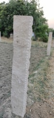 A close-up of a sturdy sign post in the ground.