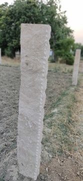 A close-up of a sturdy sign post in the ground.