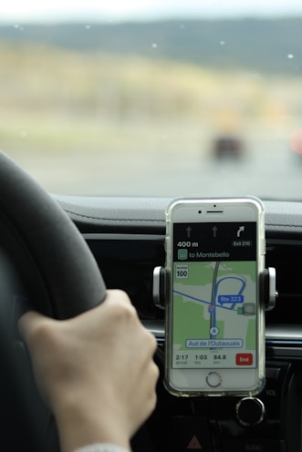 a person holding a cell phone while driving a car