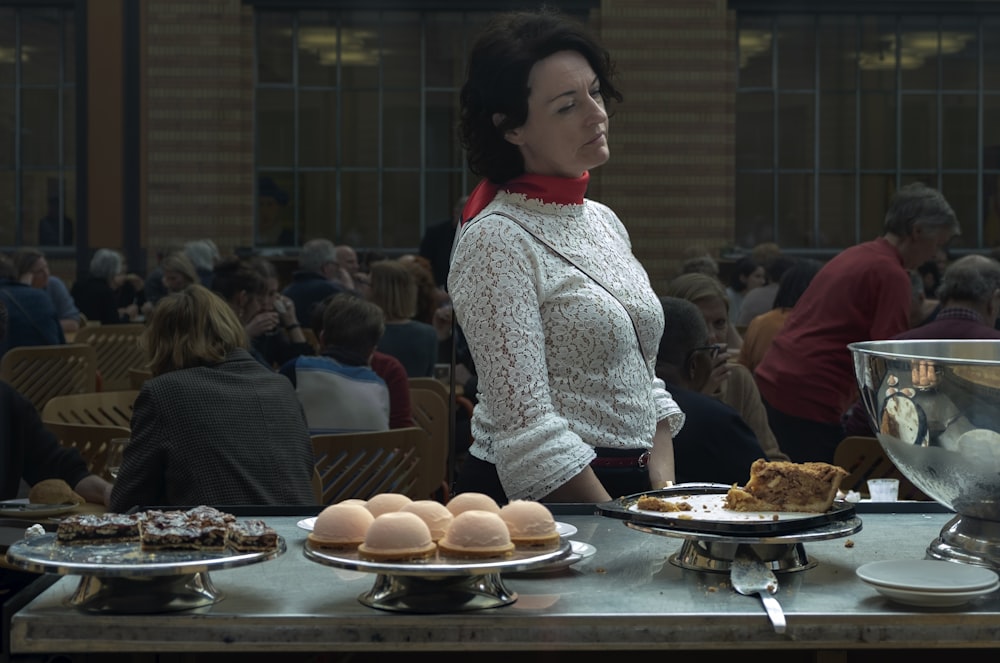 woman standing beside baked pastries