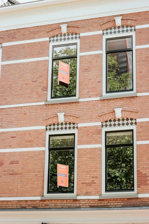 A real estate for sale sign posted in front of a single-family house
