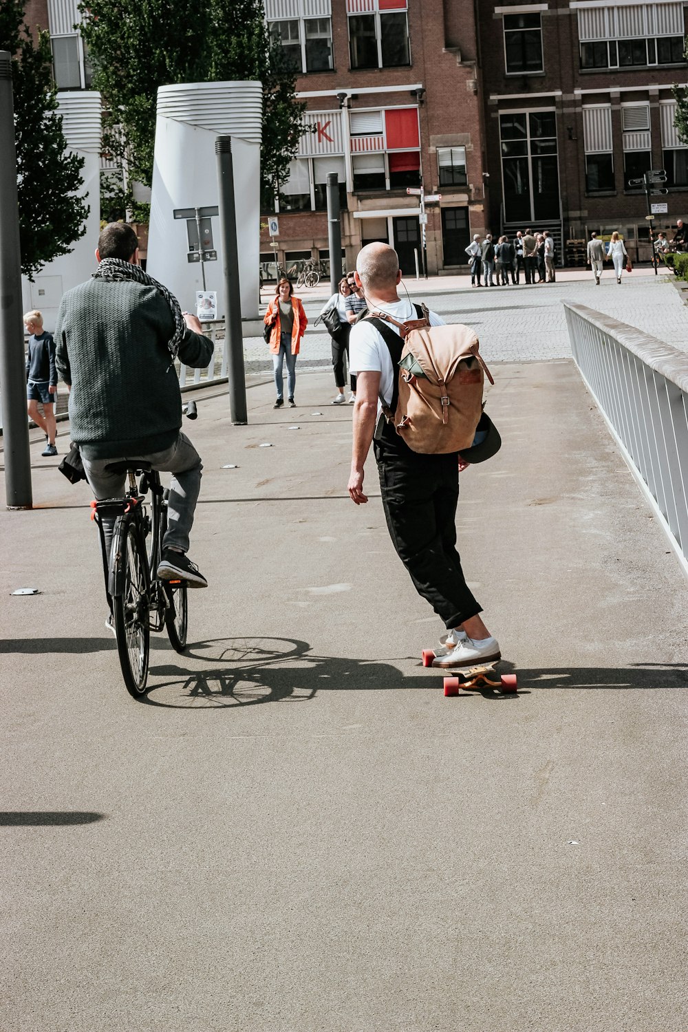 Dos hombres montados en patineta y bicicleta