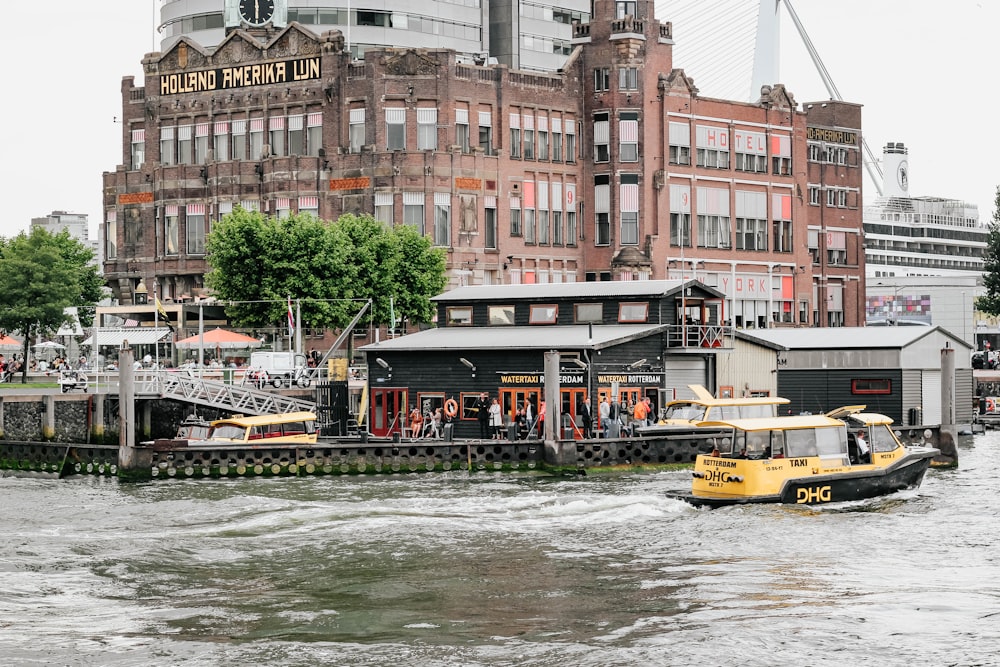 yellow and black boat beside gray and black building