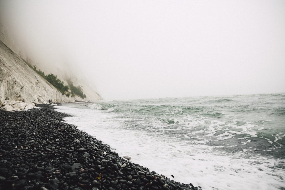 body of water near mountain at daytime