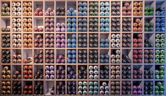 A vibrant display of paint cans and chemical containers neatly arranged in a warehouse.