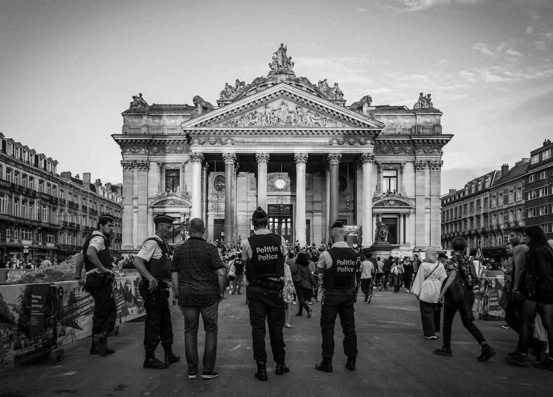 grayscale photography of people standing near building