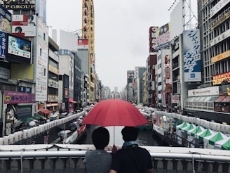 two person under red umbrella