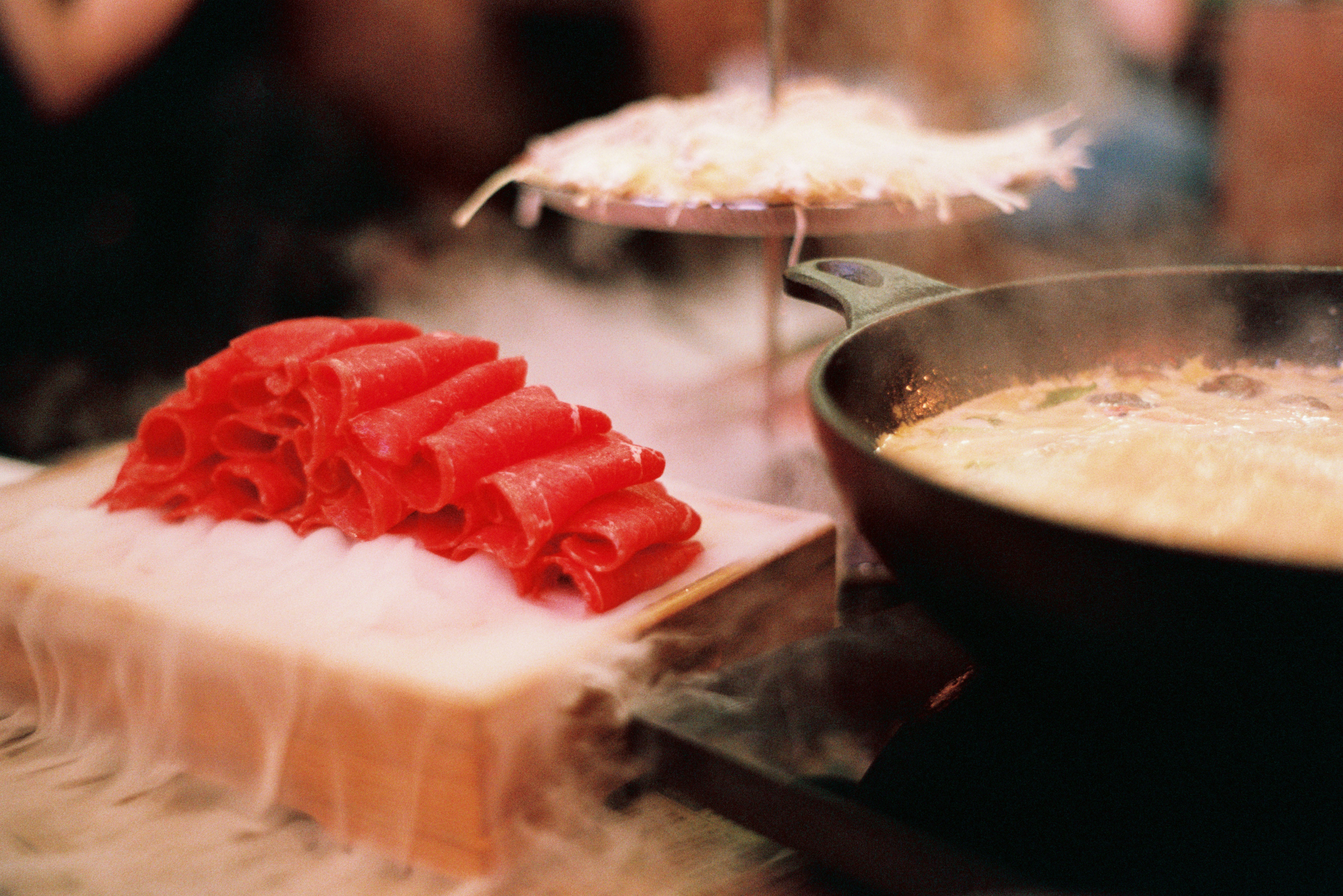 Sliced wagyu beside a steaming hot pot