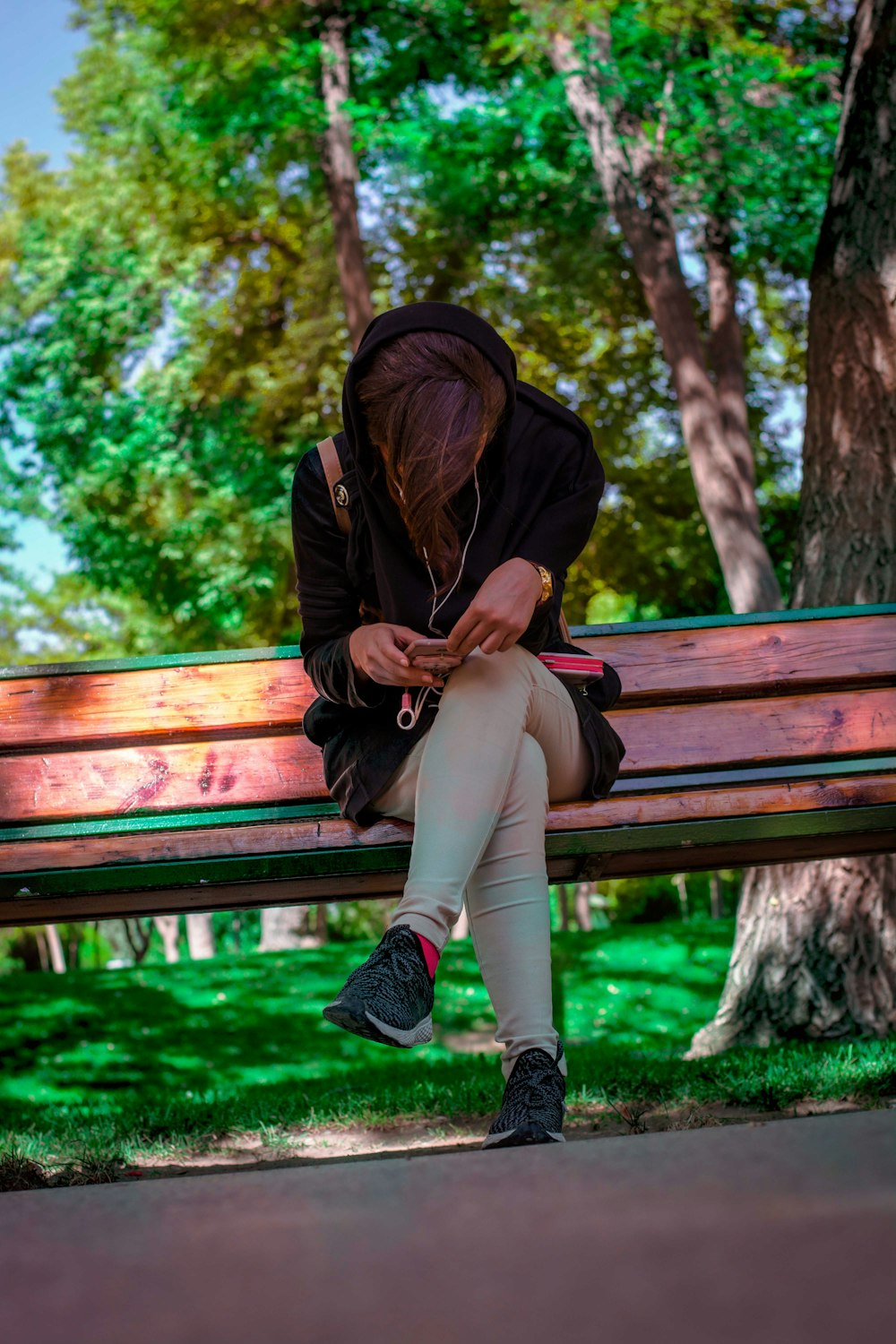woman in hoodie sitting on bench