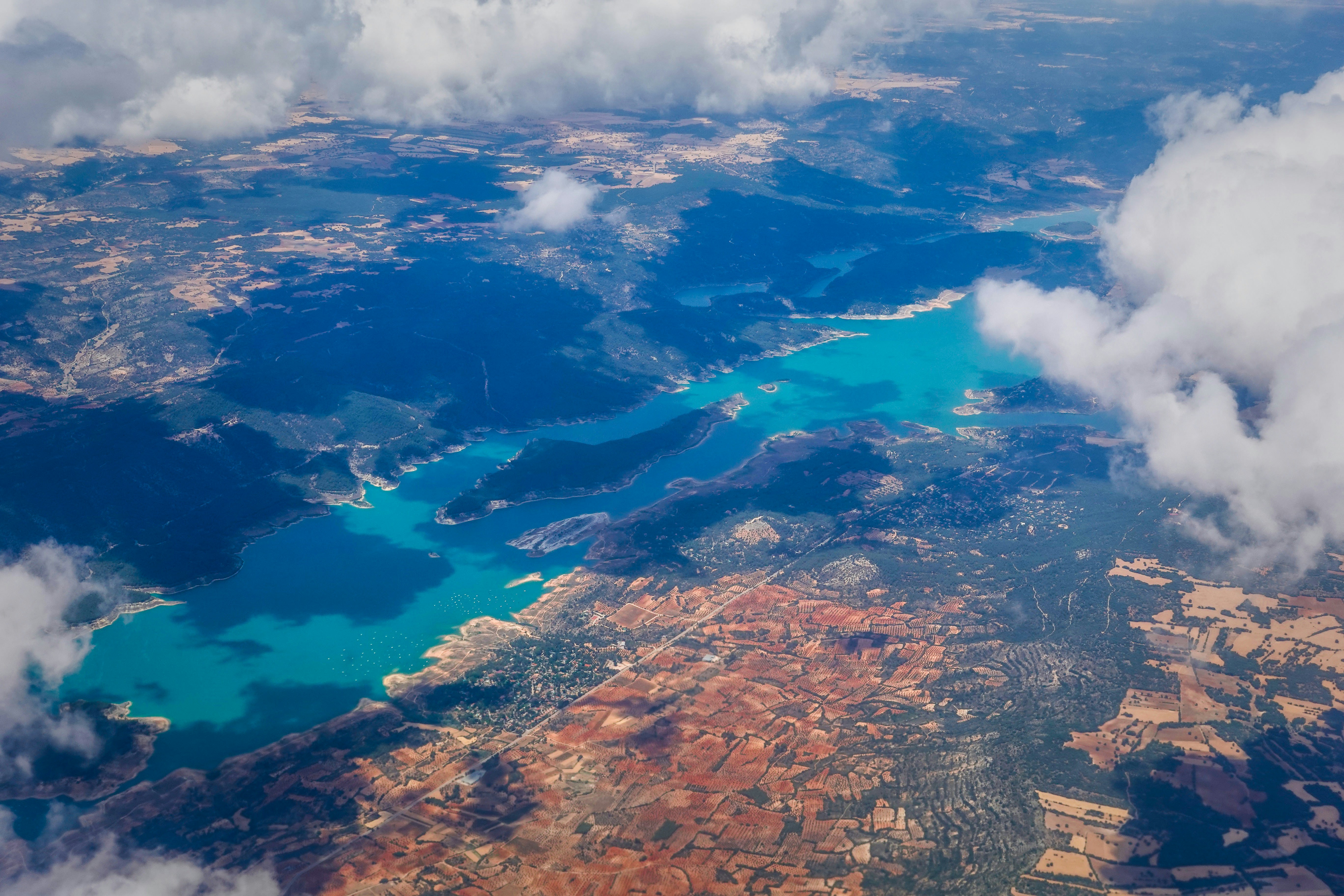 an aerial view of a lake surrounded by clouds