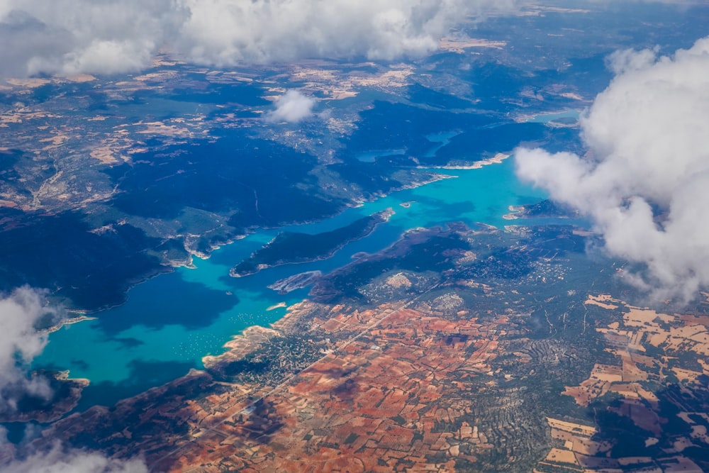 an aerial view of a lake surrounded by clouds