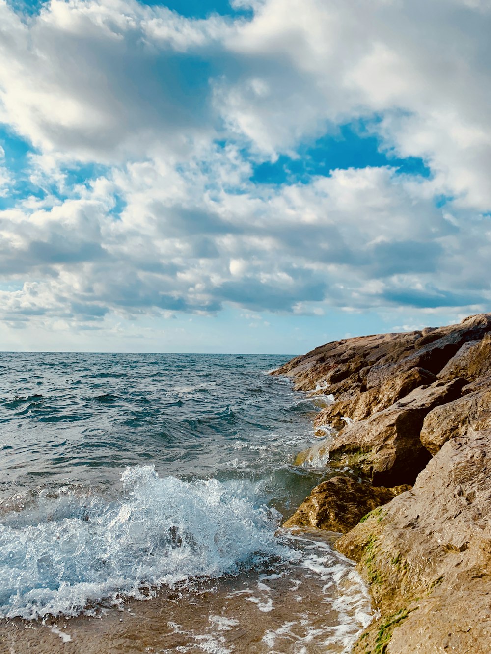 cliff beside body of water during daytime