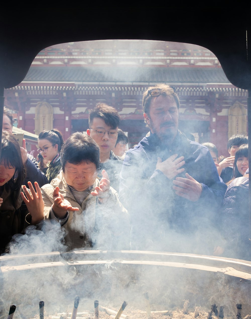 people standing near altar with incenses