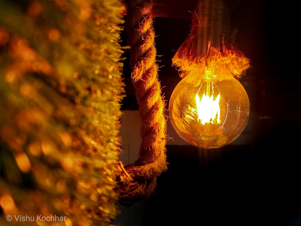 a yellow light bulb hanging from a rope