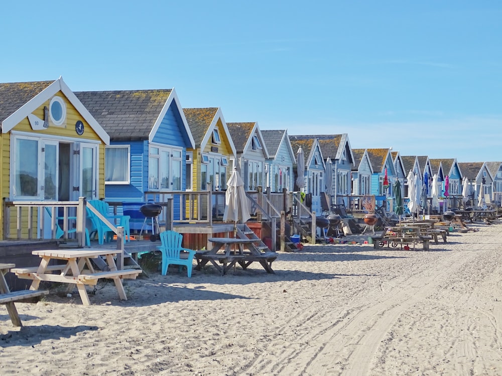 brown wooden picnic tables near wooden houses during daytime