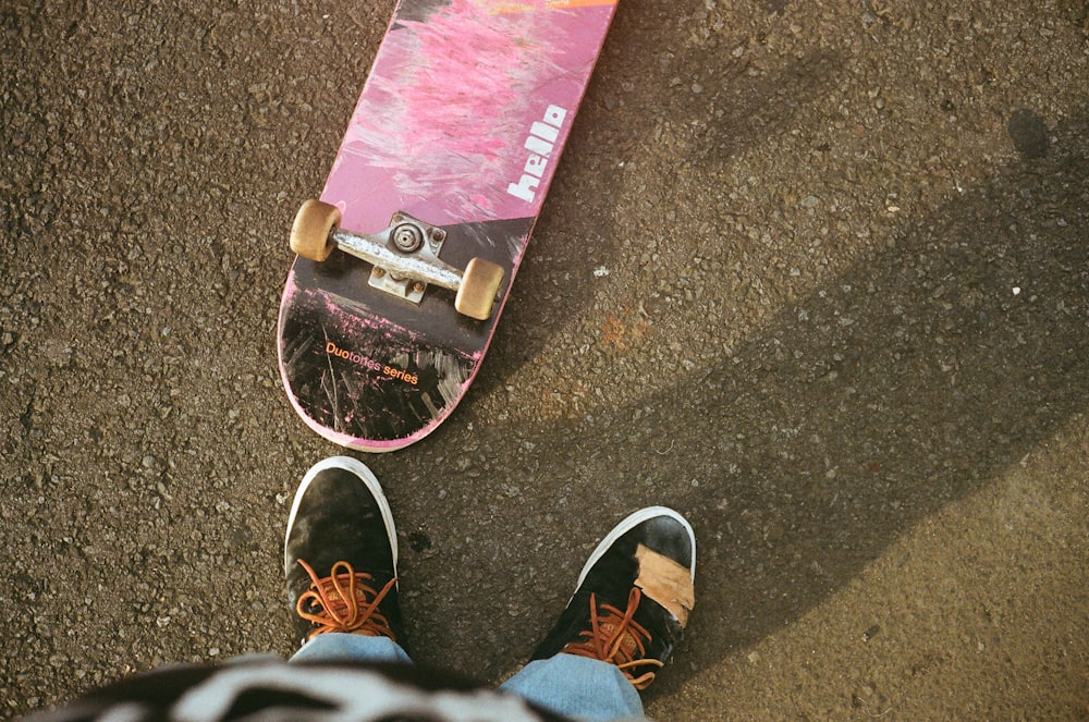 person near pink and black skateboard