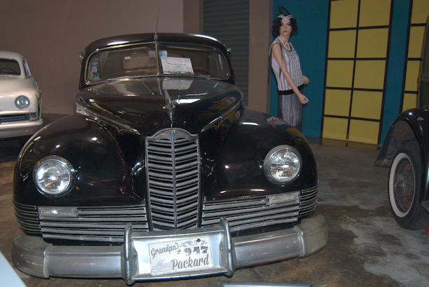 A vintage car from 1918 parked next to a modern 2026 model, symbolizing the range of vehicles serviced.